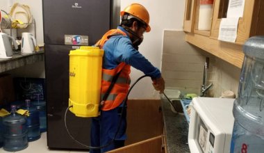 Fumigation technician with backpack sprayer